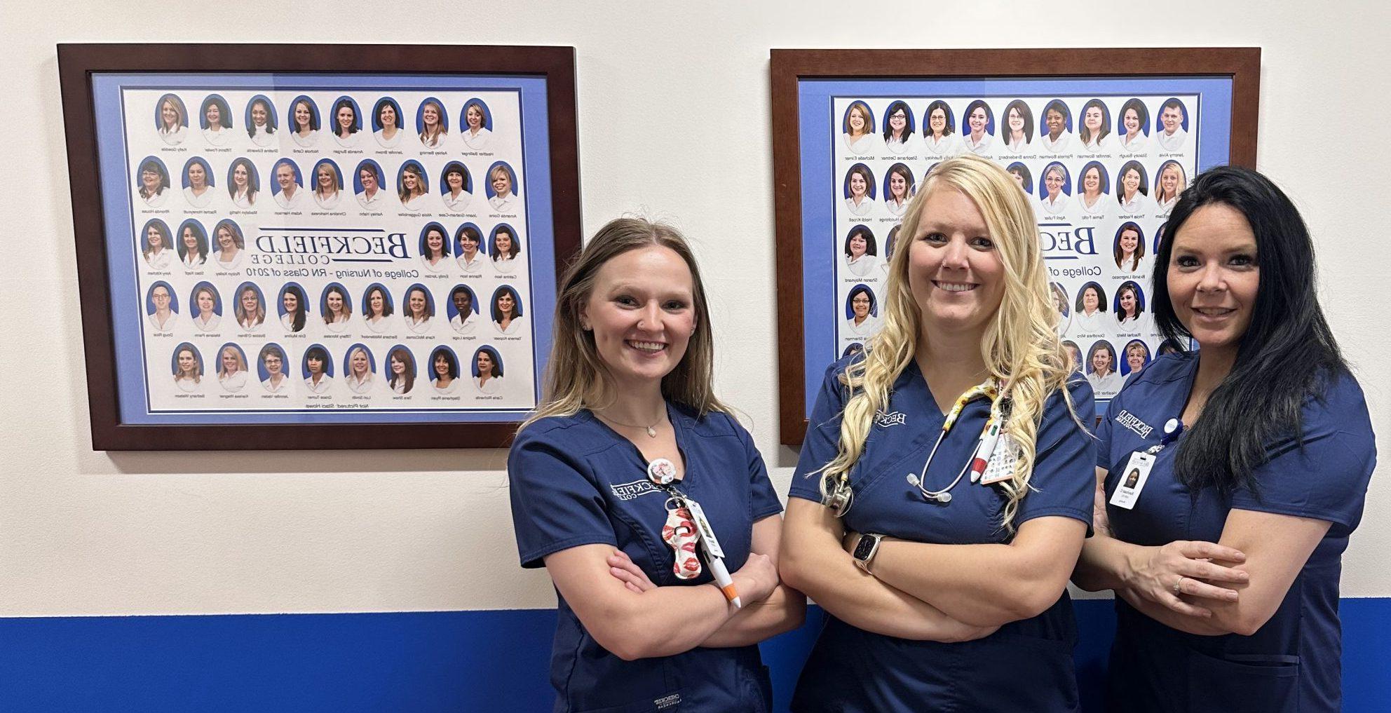 3 Nursing students at Beckfield campus looking at the graduation photos from years ago